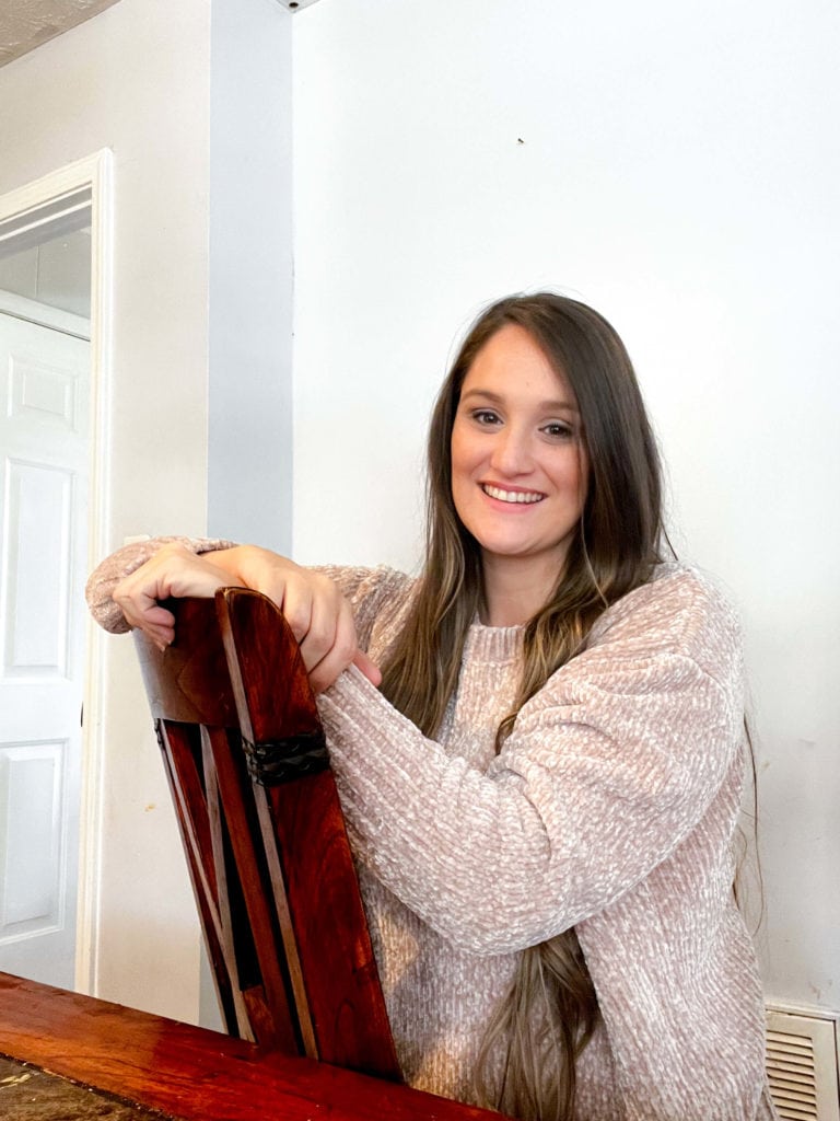 Bookkeeper Courtney Waters sitting backwards in a chair and smiling